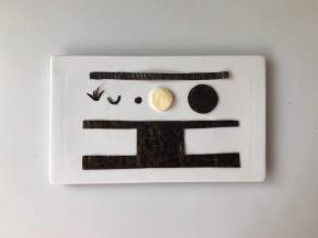 用海苔片剪出眼镜、头发、眼珠、嘴和背带裤，用芝士片剪出一个比黑色圆形略小的圆形，可以用模具压出来。（如图）