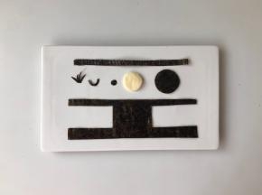 用海苔片剪出眼镜、头发、眼珠、嘴和背带裤，用芝士片剪出一个比黑色圆形略小的圆形，可以用模具压出来。（如图）