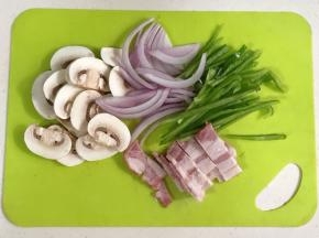 把口蘑、洋葱和青椒冲洗干净，口蘑和培根切片，洋葱和青椒切丝。
