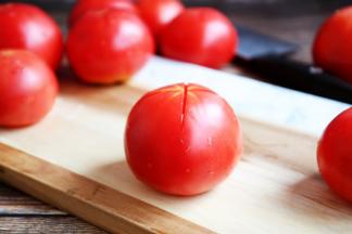 将番茄清洗干净，用小刀在每个番茄的顶部划个“十”字。