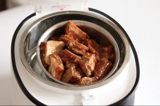 放入腌制好的蜜汁排骨（盖小盖子）。