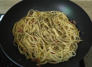 把煮好的意大利面放入，翻炒均匀，然后加入黑胡椒碎和欧芹碎。如果有新鲜的欧芹更好，味道更加清香。