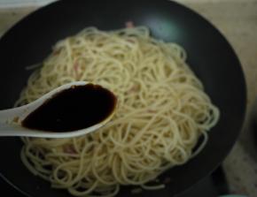 然后加一勺酱油，把意大利面翻炒均匀。如果发现面条在翻炒过程中太干，可以加点煮面水，因为煮面水里含有淀粉，不仅可以给面增加一些汤汁，也可以增加酱汁的浓稠度。