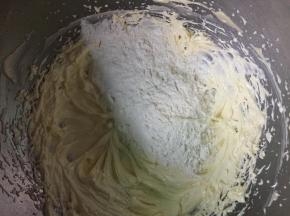 把过筛的低筋面粉倒入到黄油糊中，用刮刀拌匀。面糊拌到顺滑无干粉无颗粒就可以了。