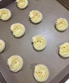 把曲奇面糊挤在不粘的烤盘中，每个曲奇之间要留有间隙，避免烘烤过程中曲奇膨胀连在一起。