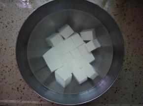 豆腐切小块，然后烧一点开水，撒一点盐在水里，然后把豆腐放进水里浸泡10分钟。浸泡完后把水倒掉。泡盐水的作用是为了去除一点豆腥味，而且我么使用的是嫩豆腐，盐水可以使豆腐变得更加结实一点，不容易碎。