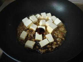 把豆腐放进锅，然后加一点生抽、老抽、水和蚝油，用锅铲轻轻地推动豆腐，不要大力翻动，嫩豆腐经不起这样蹂躏哦。