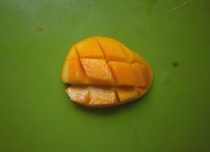 将芒果沿着核对半切开，然后划上井字纹，用勺子把果肉挖出，留一部分芒果丁作为最后的装饰，其他的放进料理机里面打成芒果泥。这个季节小台芒很适合，芒果味浓，又甜纤维又少。