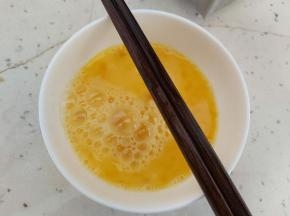 鸡蛋磕入碗内打散。