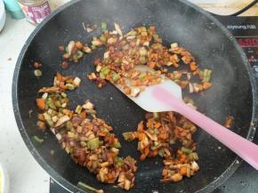 然后把胡萝卜丁、香菇丁、尖椒丁加入，翻炒均匀。