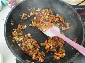 然后把胡萝卜丁、香菇丁、尖椒丁加入，翻炒均匀。