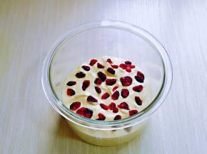 再将拌好的蛋糕糊倒入美的BB煲的玻璃内胆中，再撒上蔓越莓干，如图。