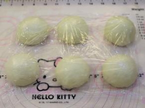 面团轻压排气后，平均分成6份，整圆盖上保鲜膜松弛15分钟。