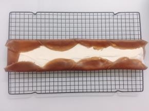 把饼皮一张叠一张的铺开，抹上淡奶油。两端和边边如图卷起来