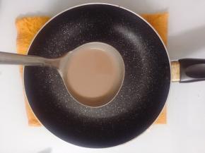 舀一半勺面糊倒入平底锅中，转动一下锅，均匀的摊开