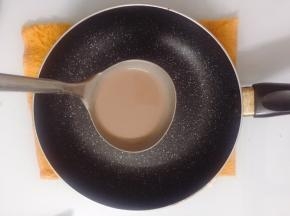 舀一半勺面糊倒入平底锅中，转动一下锅，均匀的摊开