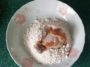 5.将腌好的鸡翅根放入裹炸粉中滚一圈拍一拍