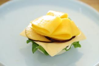 摆放上生菜，奶酪片，桃子片，芒果片，挤上沙拉酱。