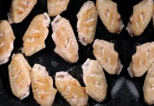 3 再下入鸡翅煎到金黄捞出待用。