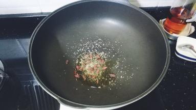 不粘锅里热油，放入蒜盐、糖、枸杞子