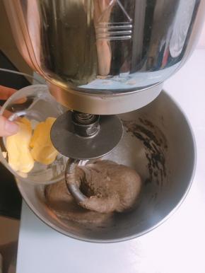 面团表面揉至光滑后加入软化的黄油，开低档揉至黄油完全融合于面团