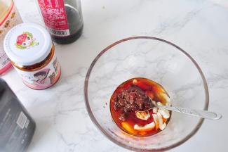 将醋1勺 辣椒油1勺 花椒面1小勺 香菇小丁1大勺 芝麻油1勺、鸡粉、蒜拍碎后放在碗中。鸡粉不喜欢可以不加。蒜粗粗的拍碎即可，我放了三四瓣，您可以根据自已的喜好决定用量。