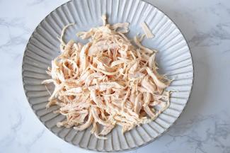 将煮好的鸡脯肉撕成细丝备用。鸡脯肉很好撕，顺着纹路直接撕开即可。