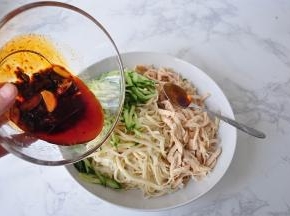 将面条捞出，把黄瓜丝、鸡丝放入，倒入调好的调味料即可。