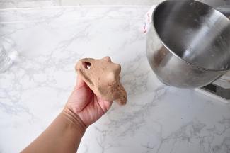 揉至扩展阶段后，加入黄油，再揉至完全阶段。贝果的面团含水量少，不要因为面团硬而加入过多的水，这样它的组织才比较紧实有嚼劲。只有将面团揉到完全阶段，面团的延展性才能更好，在整形时才不容易回缩。烤完后表面才能较光滑且不容易裂开