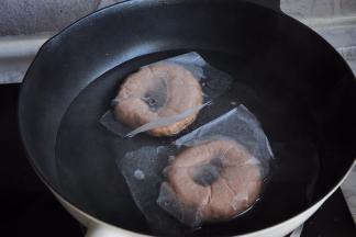 发酵的时间差不多时，就开始将水和糖放在锅中煮沸，然后转小火，将发酵结束的贝果面团放在糖水中，每面煮30秒。底部最好垫上油纸，不用刻意撕掉，在锅中它会自已脱落。