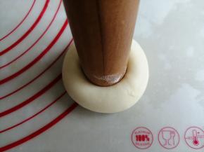 擀面棍的一头沾点面粉，在面团中间用力压一下