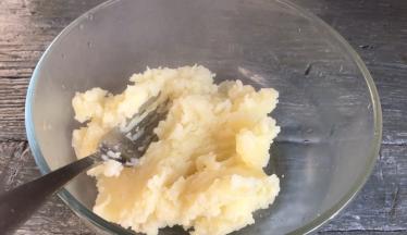 取出蒸熟的土豆片，倒入大点的容器内，压成泥状