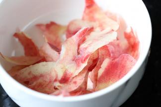 开始熬水蜜桃酱：水蜜桃的用细刷刷掉皮上的细毛，皮刨成一片一片。