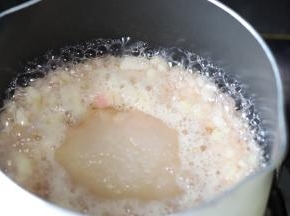 捞掉水蜜桃皮，放入水蜜桃粒和糖。