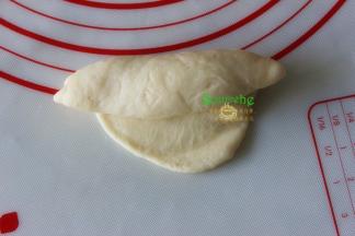 擀好的面皮，从上往下卷起，变卷变收紧，要想接口小，擀面的时候面片的周边擀薄些。如果卷好的面团形状不理想，可以拿在手心做适当的调整成橄榄形面团。