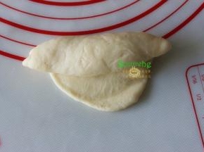 擀好的面皮，从上往下卷起，变卷变收紧，要想接口小，擀面的时候面片的周边擀薄些。如果卷好的面团形状不理想，可以拿在手心做适当的调整成橄榄形面团。
