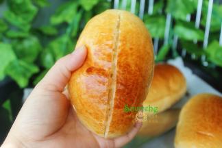 烤好的面包取出，放入架子上冷却，取一个面包，用面包刀从中间切块，不要切断。