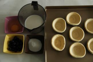 准备好材料，挞皮买的市售的，提前从冷冻里取出回温。排入烤盘中。