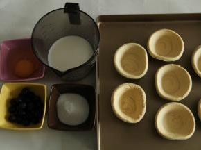 准备好材料，挞皮买的市售的，提前从冷冻里取出回温。排入烤盘中。