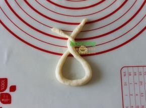 捏起长条的两头，将长条扭2圈一个圆形。其实就是下边一个大圆形，上面接在一起扭了两圈。