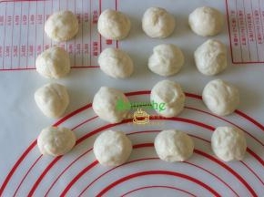 将发酵后的面团压出气体，再次揉圆，分成16等分，盖上保鲜膜静放15分钟。