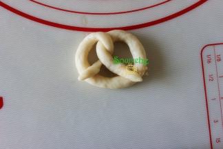 将两头往下翻过来，粘在圆圈底部，这种饼干的面团非常软，建议扭好的饼干胚，直接在烤盘上，比在擀面台上要省事。