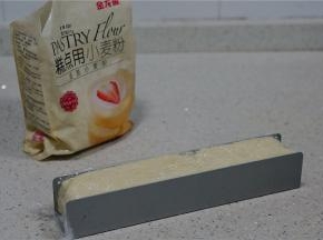 在饼干U型模里先码上一张保鲜膜，再将拌好的面糊填至模具里面。