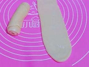 时间到后取一个面卷，面卷竖着用擀面杖来回擀的长舌状再卷起，盖上保鲜膜醒15分钟。(这样反复两次。 擀长舌状再卷起来，再擀长舌状，卷起来，同样操作方法。）