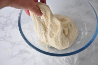 把面团揉光滑，盖上保鲜膜，静待它发酵起来了至两倍大，用手拉起面团，有蜂窝状。注意不要把面团发过头，那样会产生酸味，发过头的面团用手一碰就会变塌。