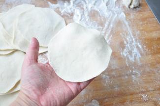 擀成中间略高，边缘较薄的面剂。