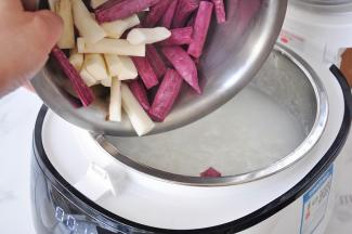 将山药和紫薯放在锅中。盖上盖子继续煮。