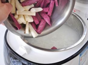 将山药和紫薯放在锅中。盖上盖子继续煮。