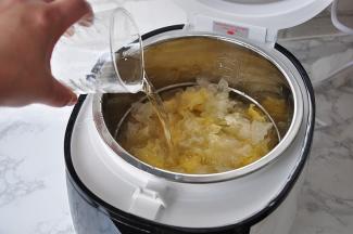 将银耳放入电饭煲中，然后加入适量的水，我半朵银耳，把水加到了锅胆中2L刻度。这个您可以根据自已的喜好来，稠一点的，稀一点的，随心所欲。