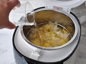 将银耳放入电饭煲中，然后加入适量的水，我半朵银耳，把水加到了锅胆中2L刻度。这个您可以根据自已的喜好来，稠一点的，稀一点的，随心所欲。